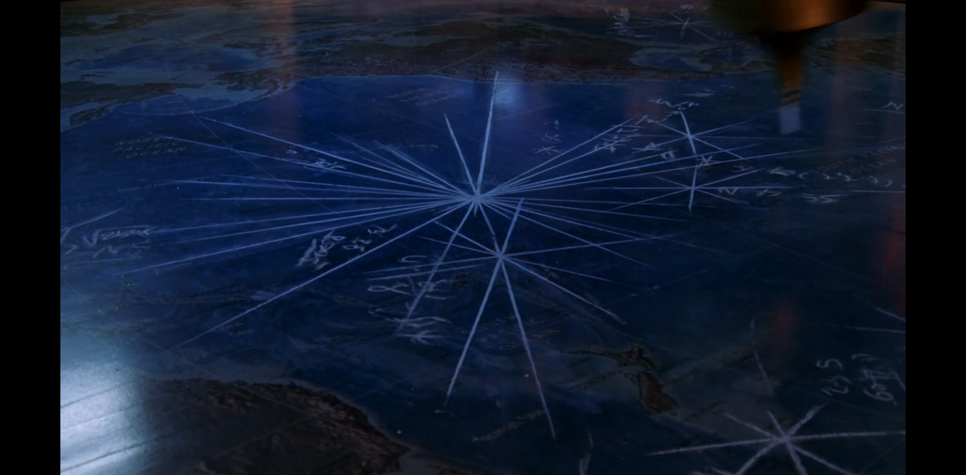 A series of asterisks etched into a marble floor that has a map of the earth inset.