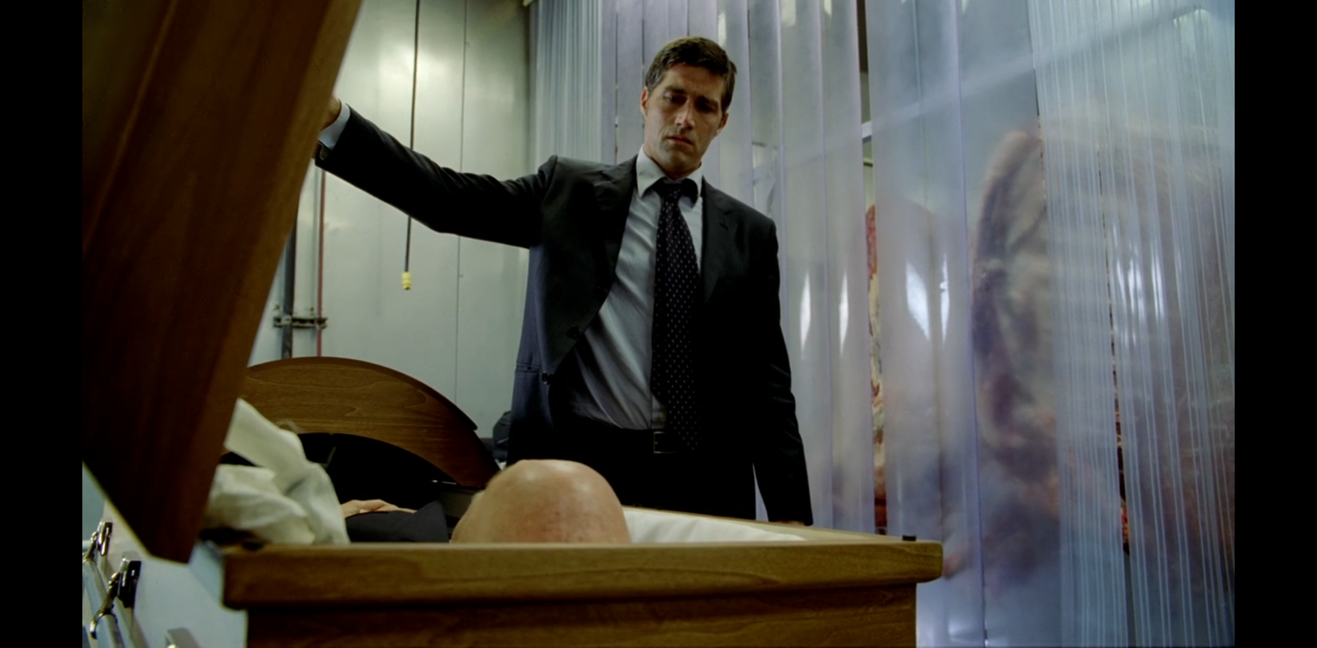 In a meat locker, Jack opens a coffin. John Locke's bald head can be seen lying inside.