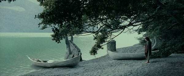Still from The Lord Of The Rings: The Fellowship Of The Ring. Frodo stands beside the boats his group has used to traverse the Anduin River.