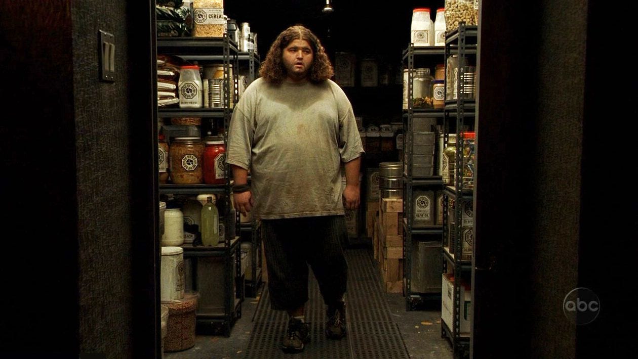 Hurley stands mouth agape in the Swan Station's pantry, which is filled with racks of food and supplies.