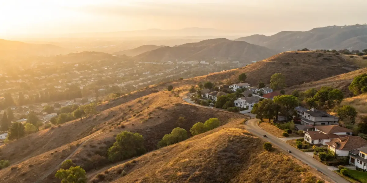 California homes in a high fire hazard severity zone surrounded by dry hills and scattered trees.