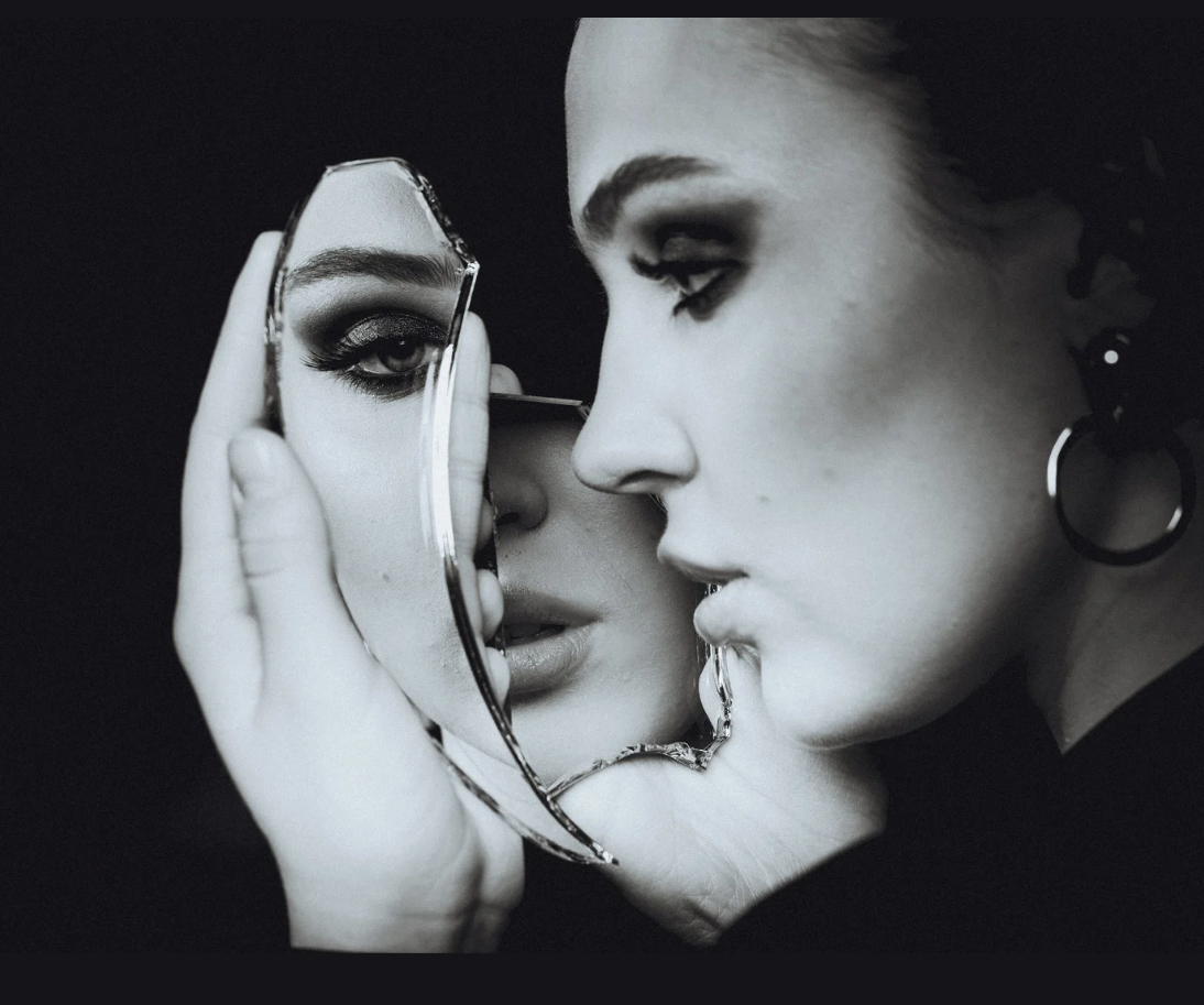 A young girl looks at herself in a fragmented mirror