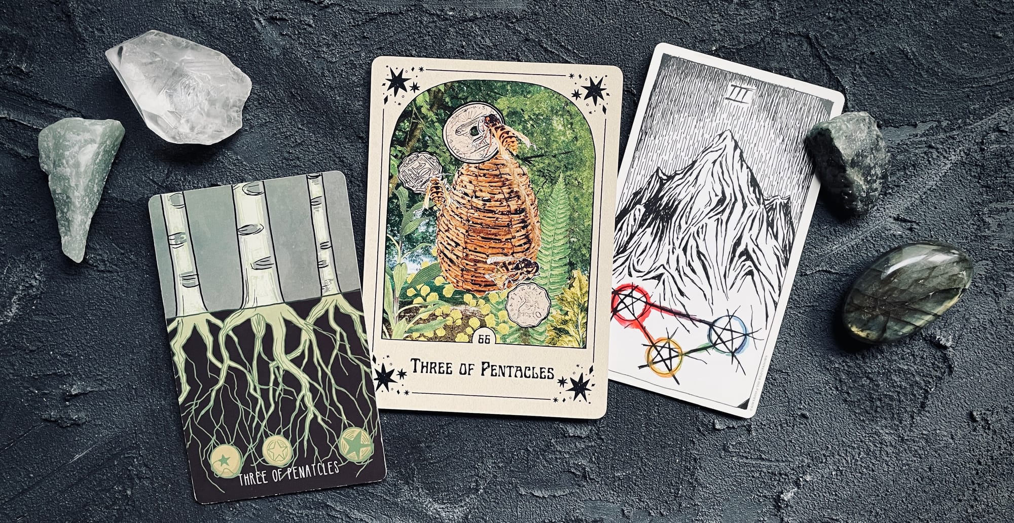 three of pentacles from three different tarot decks