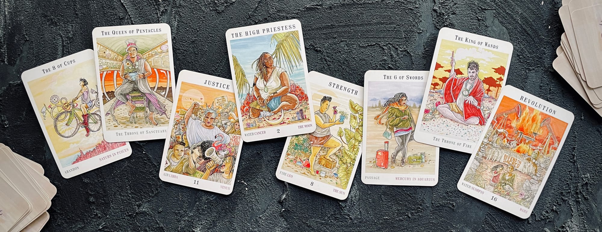 from left to right: 8 of cups, queen of pentacles, justice, high priestess, strength, 6 of swords, king of wands, revolution (tower) from the next world tarot