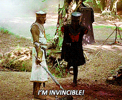 black knight shouts "i'm invincible" while hopping on one leg and bumping into another knight holding a sword, from "monty python and the holy grail"