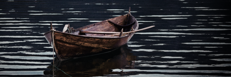 wooden rowboat on rippling water