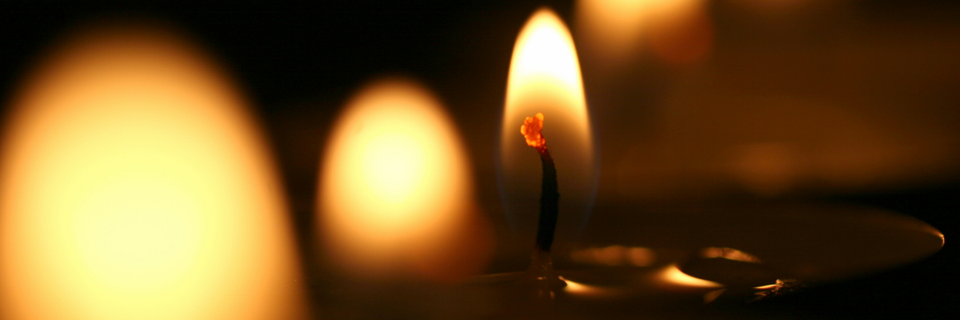 close up on a candle flame, with other flames in the foreground and background
