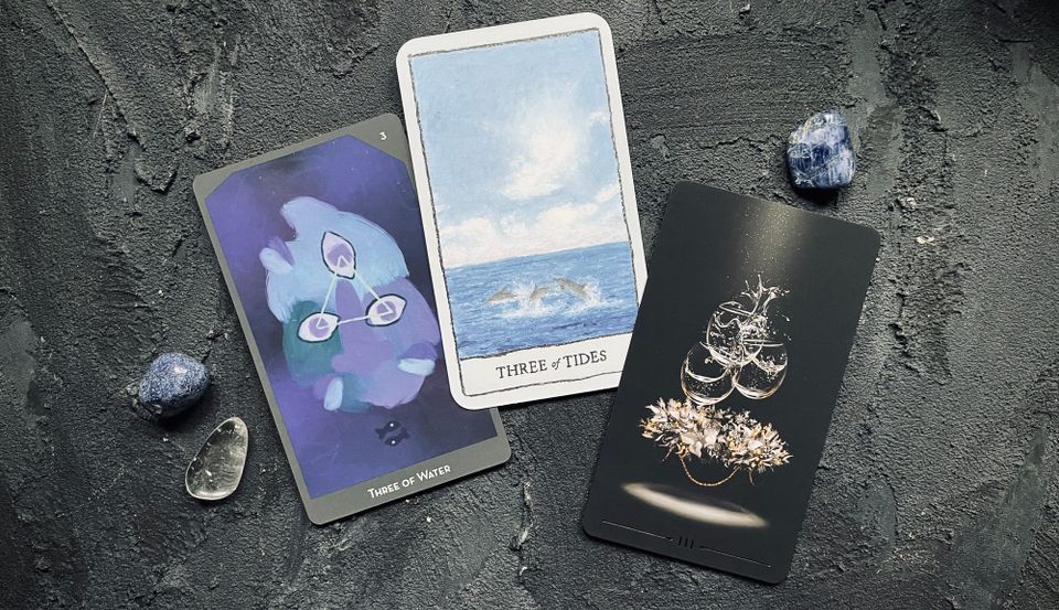 three of cups from the lineages of change tarot (left), the mindscapes tarot (center), and the true black tarot (right)