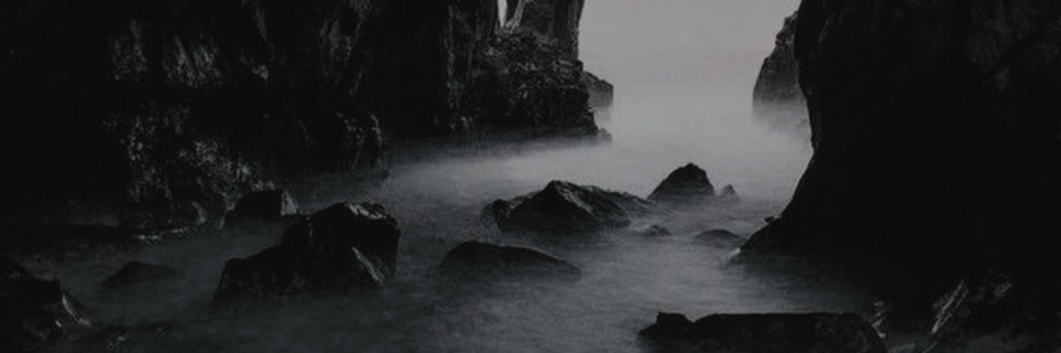 photo of water and mist within a dark rock cave