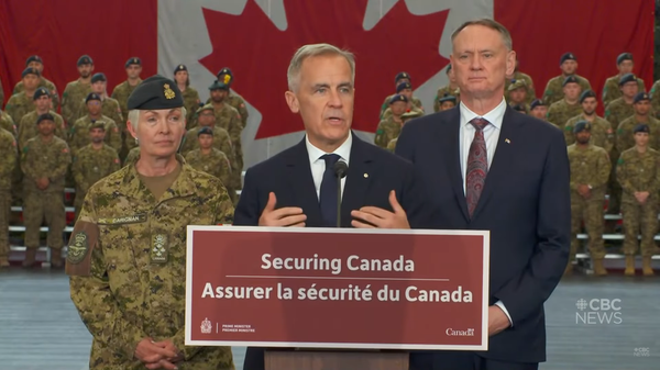 Prime Minister Mark Carney Stands at a podium labeled "Securing Canada" surrounded by military personnel in front of the Canadian flag