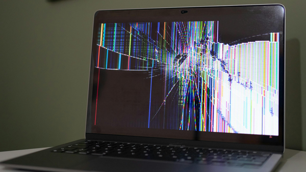 A laptop with a broken screen sitting on a table