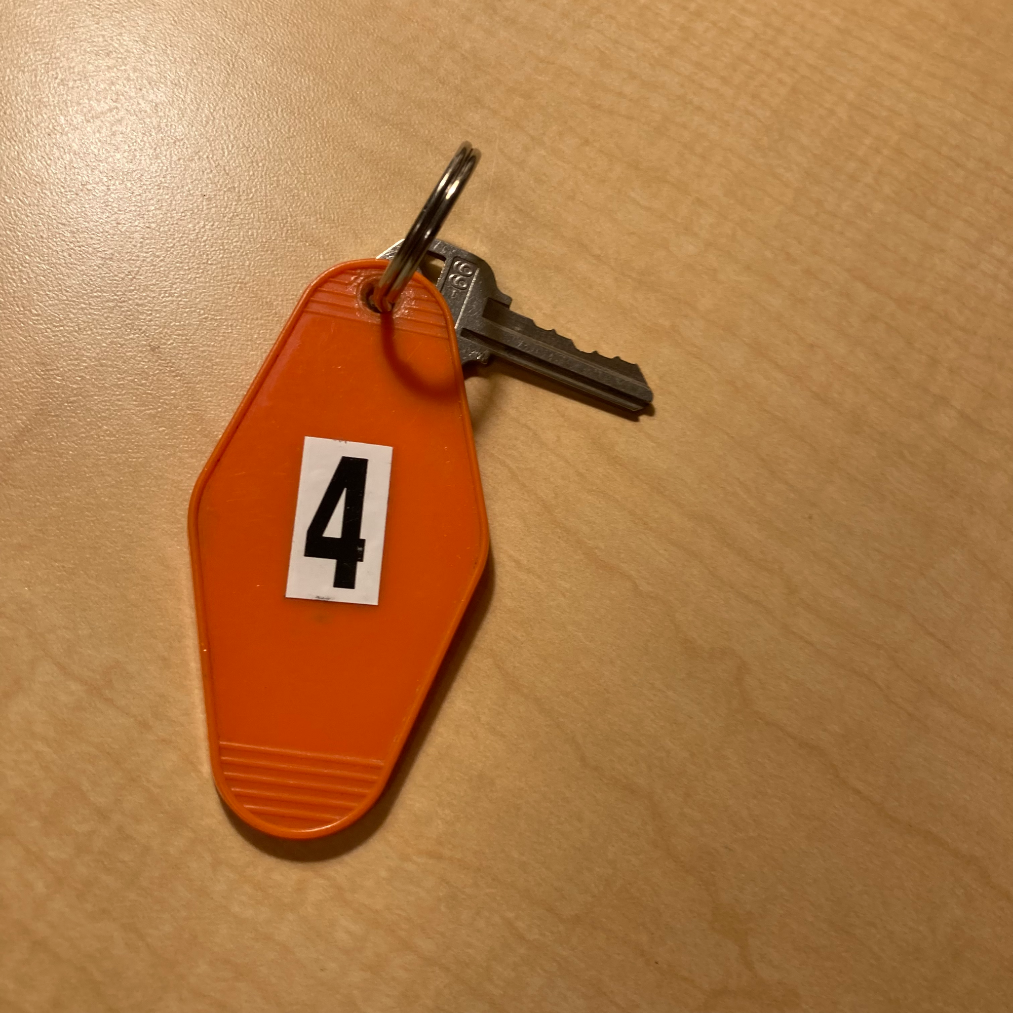 Photo of an old-fashioned motel room key with an oversized orange plastic fob