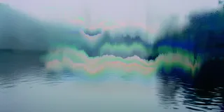 Glitched landscape of muted greens and pinks reflected in still water