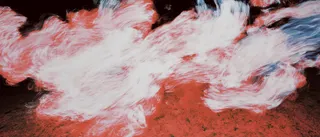 Abstract motion blur of red and white light against a dark background