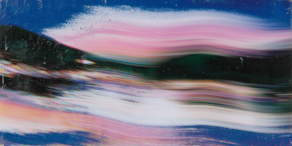 Motion blur of pink and blue streaks across a landscape