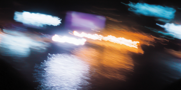 Motion blur photograph of city lights at night in blue, orange and purple