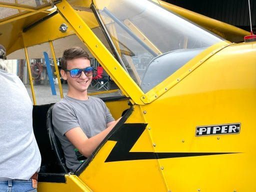 Smiling Student Pilot Sitting in Piper Cockpit