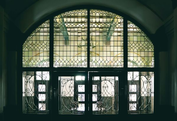 A leaded glass window looks onto large open space