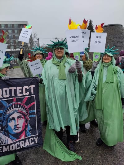 Women dressed as the statue of liberty protest Trump's policies