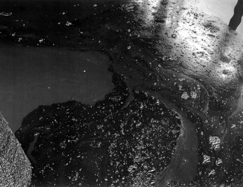 A disgusting bubbly black foam with an oily sheen on salt water.