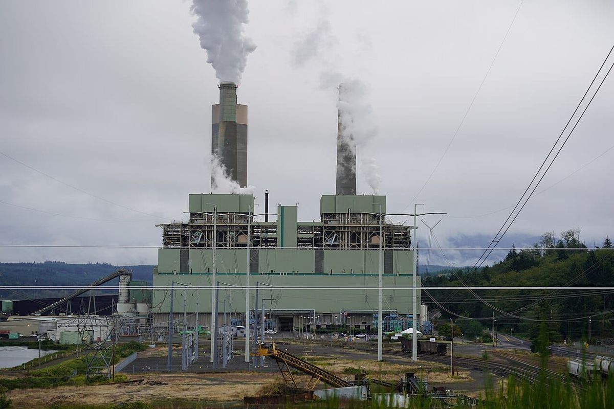 A power plant emits clouds of pollution from two smokestacks.
