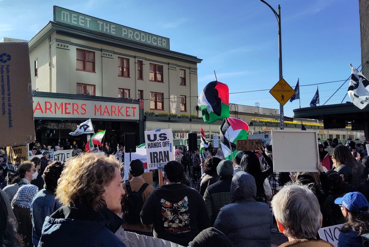 Protestesters fill Pike Place market holding signs that read US hands off Iran.