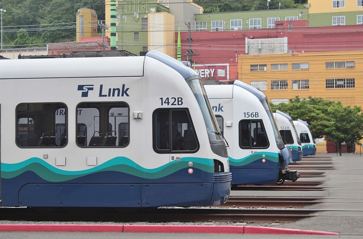Light rail cars at the end of tracks are lined up next to one another.
