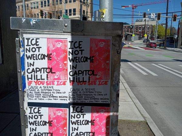 Posters on a utility box in Seattle's Capitol Hill neighborhood say that ICE is not Welcome in Capitol Hill and advising people what to do if they encounter ICE