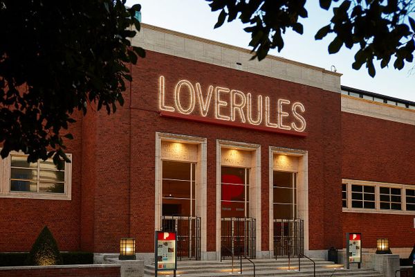 The front facade of the Portland Art Museum with a neon art sign over the door that read "LOVERULES"
