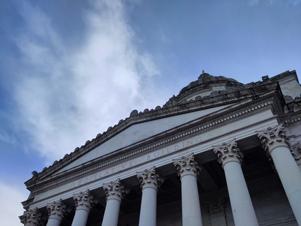 A view of the Greek columns and architecture of the Washington legislative building from below.