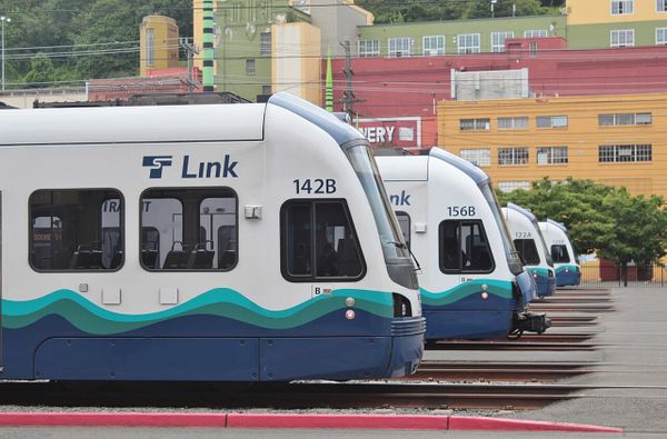 Light rail cars at the end of tracks are lined up next to one another.