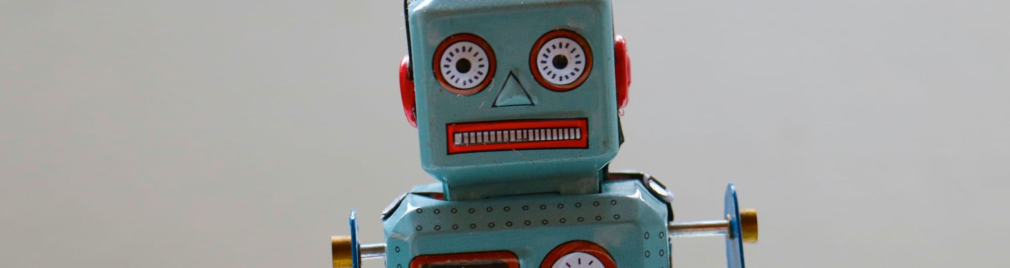 A retro robot toy with a slightly deranged mechanical faces stares at you.