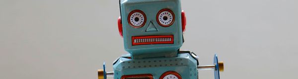 A retro robot toy with a slightly deranged mechanical faces stares at you.