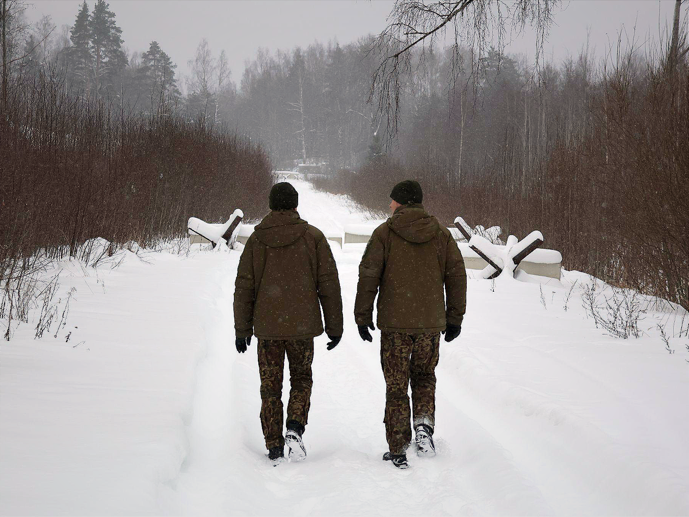 Latvian border guards patrol near a new fence separating NATO-hosted military infrastructure and areas in Latvia from Russia.