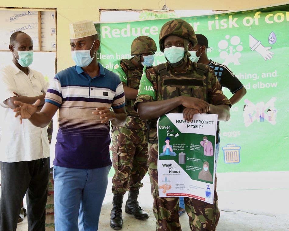 Kenyan soldiers with the African Union Mission in Somalia talk about how to prevent the spread of COVID-19