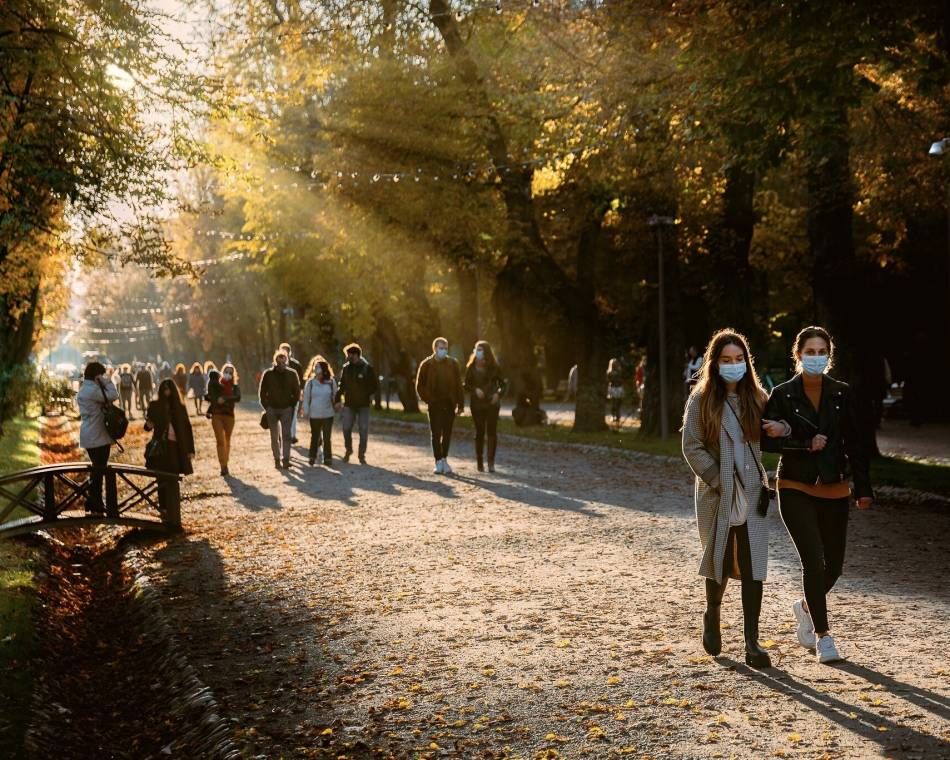 People wearing masks as they walk through Central Park Simion Bărnuțiu in Romania's Cluj-Napoca