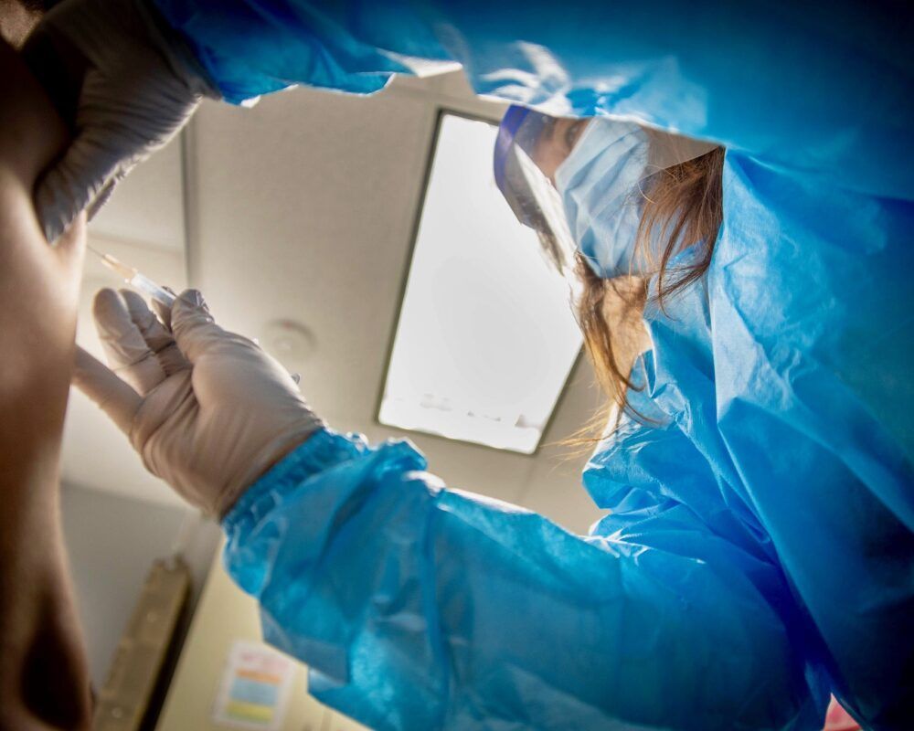 A registered nurse in San Diego administers a shot to a patient for a trial of AstraZeneca’s COVID-19 vaccine candidate.