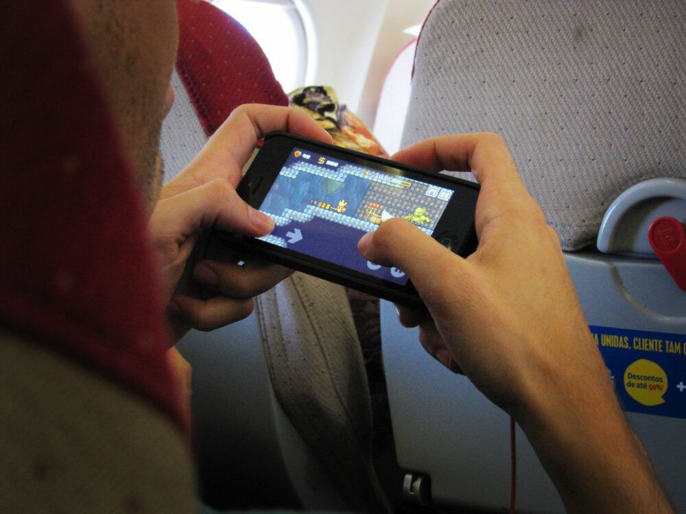 A passenger playing video games on a plane. 