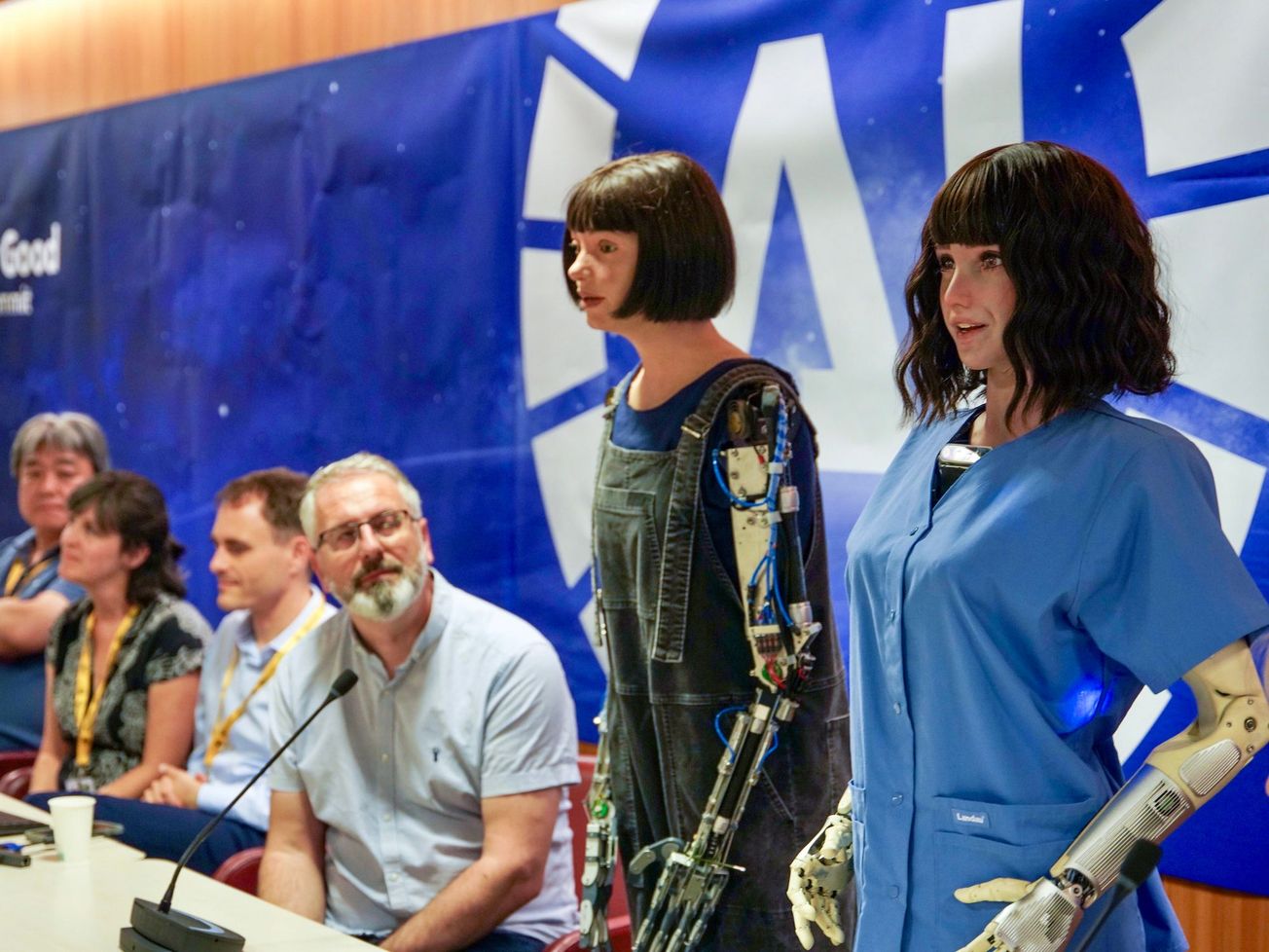 A panel of AI-enabled humanoid robots at an ITU press conference.
