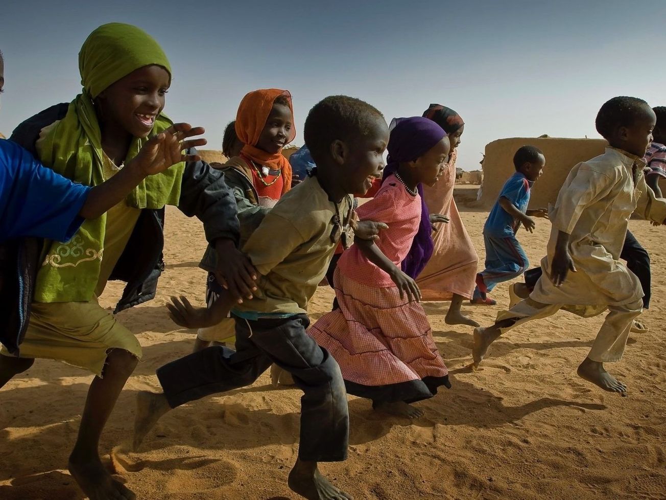 Young children race each other at a refugee camp in Eastern Chad