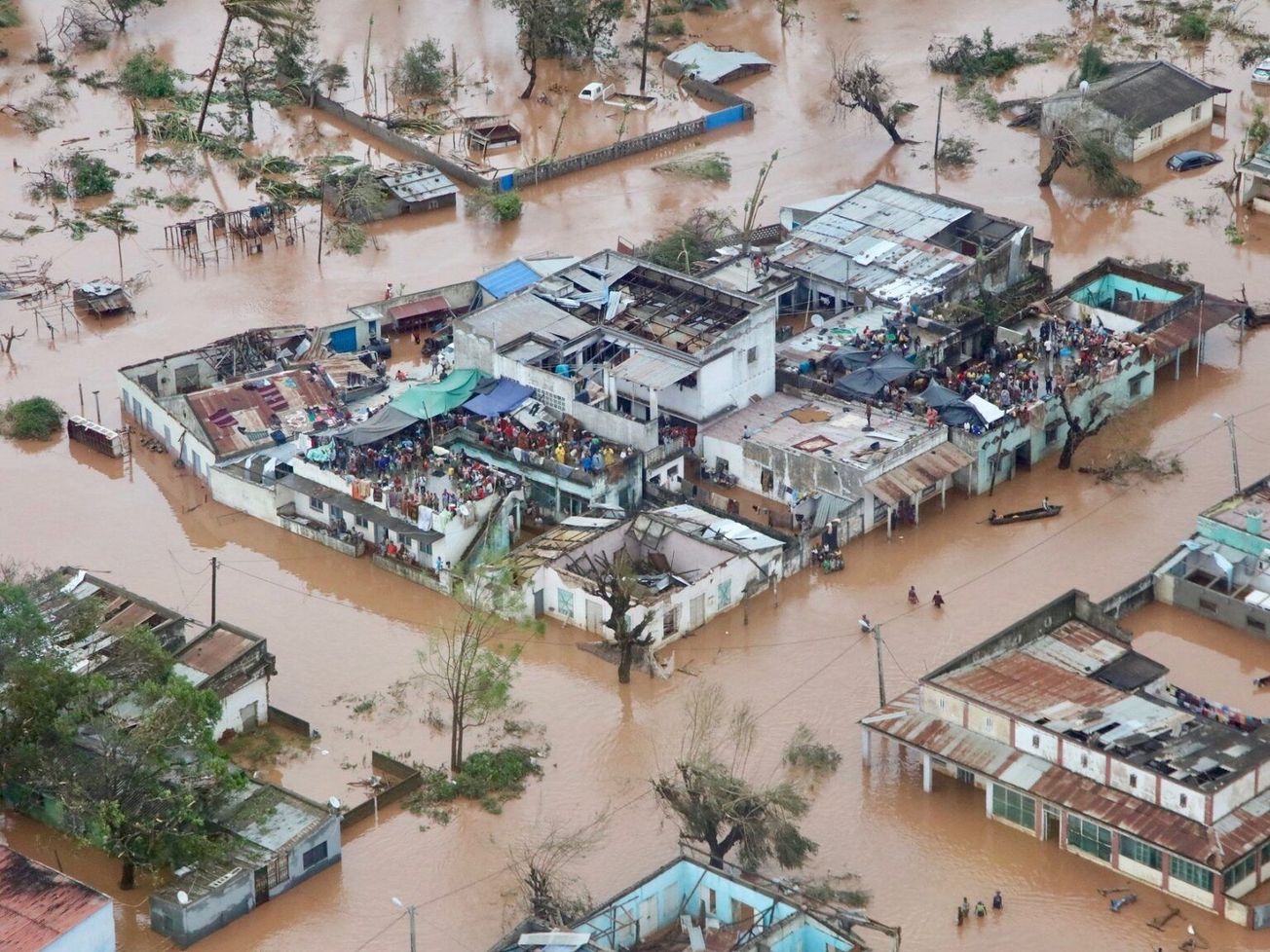 People take refuge on the roofs of buildings following flooding caused by 2019's Cyclone Idai in Mozambique