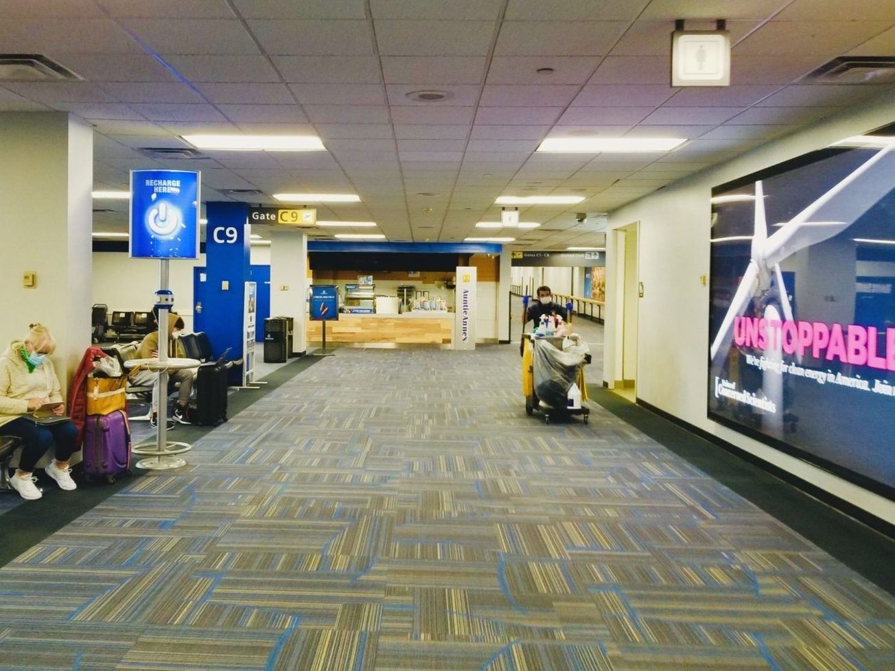 A masked traveler and cleaner in Washington's desolate Dulles International Airport