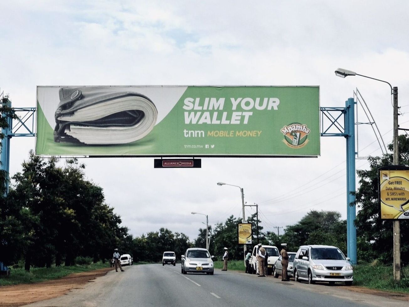 A highway ad for mobile banking above a police checkpoint in Malawi