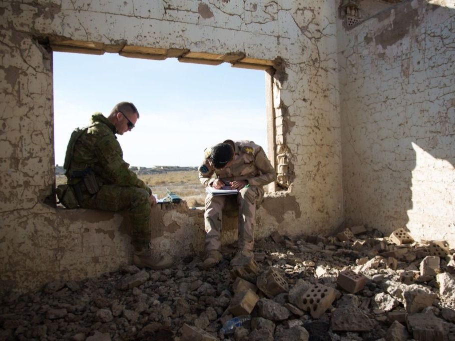 An Iraqi soldier gets training from an Australian sergeant in how to call for air support