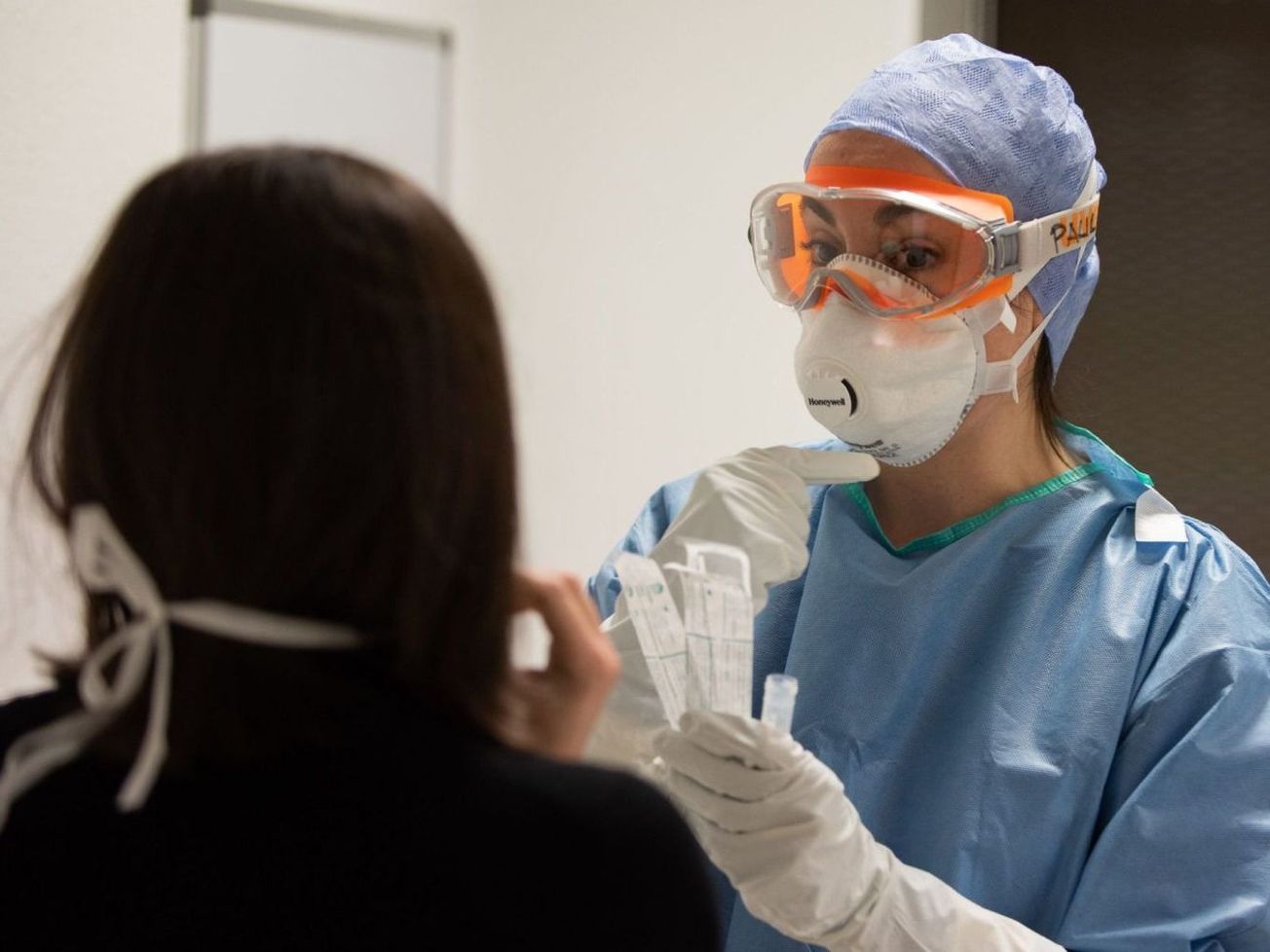 A medical worker treats a patient for coronavirus infection at Hospital Clínic i Provincial de Barcelona