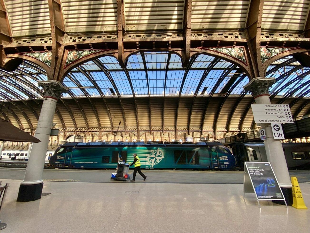 A cleaner at a deserted train station in York, U.K. on a morning in mid-May