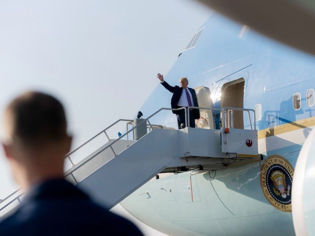 U.S. President Donald Trump waves while boarding Air Force One en route back to Washington