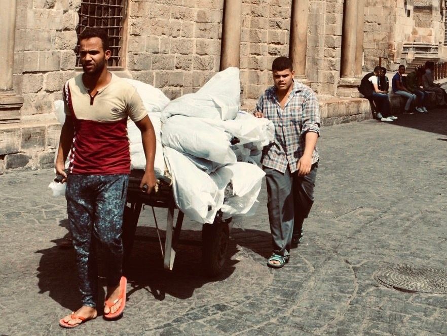 Young workers wheeling goods through Cairo's streets