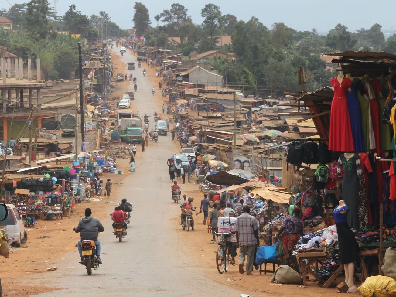 Market vendors and homes along a road in Mukono, Uganda