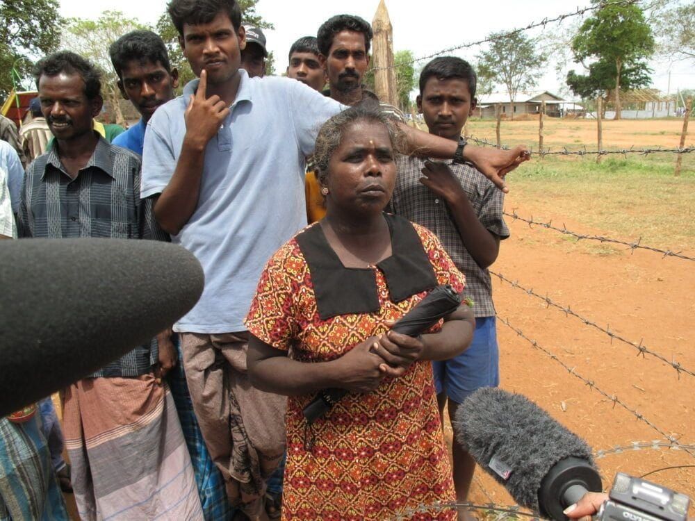 Residents behind barbed wire at Sri Lanka's now-shuttered Manik Farm refugee camp